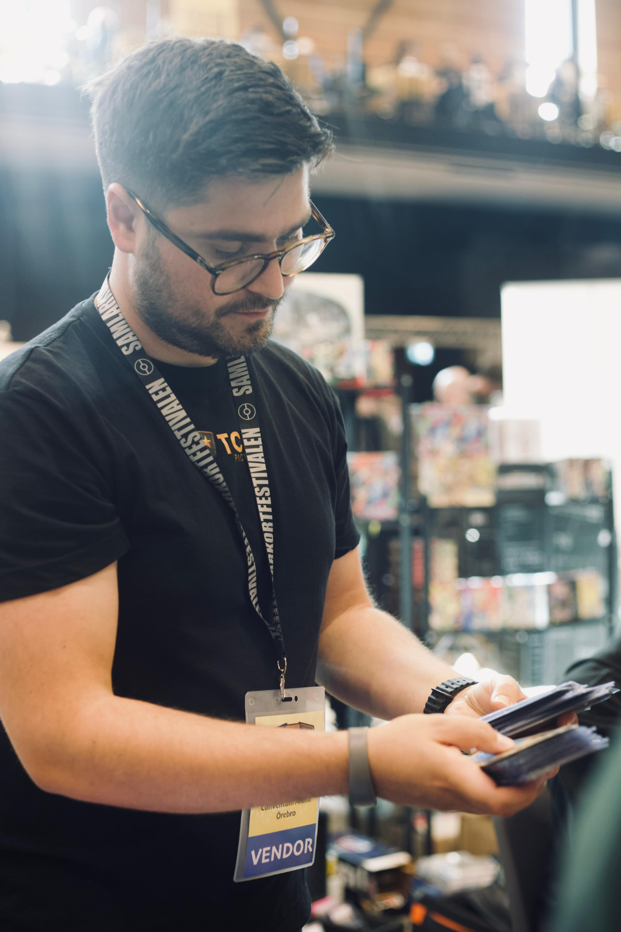 TCG Picks bläddrar igenom kort i pärm på mässan